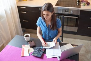 A woman is preparing a house budget